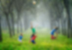 Children playing with ball in a foggy forest 